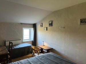a bedroom with two beds and a desk and a table at au point du jour Ch3 in Récourt-le-Creux