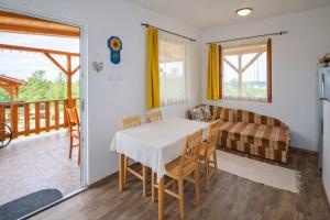 a dining room with a table and chairs and a couch at Ádám nyaralóház in Balatonalmádi