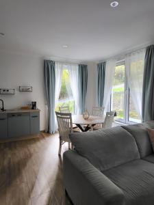 a living room with a couch and a table with chairs at Ferienwohnung Zum Adlernest in Hellenthal