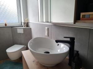 a bathroom with a white sink and a toilet at Ferienwohnung Zum Adlernest in Hellenthal +15 photos