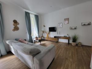 a living room with a couch and a tv at Ferienwohnung Zum Adlernest in Hellenthal