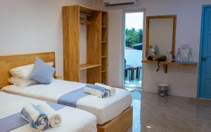 a bedroom with two beds with towels on them at Buceo Inn Mathiveri in Mathiveri