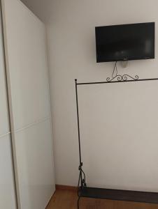 a flat screen tv on a stand in a room at Dimora Victoria in Ascoli Piceno