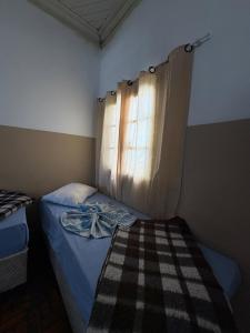 a small bedroom with a bed and a window at HOTELSÃORAFAEl in Água Boa