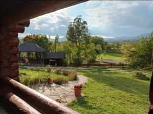 a view of a garden from a house window at Blueberry Blockhouse in Hărniceşti