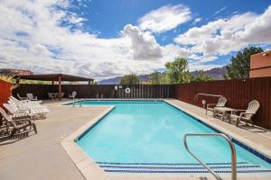 a large swimming pool with chairs and a table at Castillo De Las Rocas 3418 in Moab
