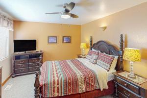 a bedroom with a bed with a dresser and a television at Castillo De Las Rocas 3418 in Moab