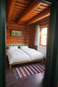 a bedroom with a bed in a wooden room at Blueberry Blockhouse in Hărniceşti