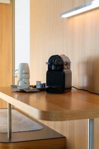 a table with a coffee maker and a toaster on it at FIRMAMENT Hotel in Feldkirch