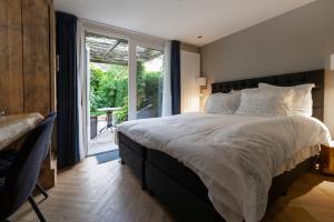 a bedroom with a large bed and a large window at De Roos Leeuwarden Bloementuin & Biodynamisch Ontbijt in Leeuwarden