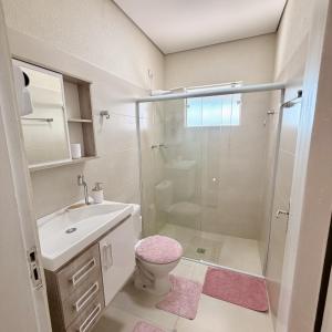 a bathroom with a shower and a toilet and a sink at Chalé Rosa - Top Country Ranch in Boituva
