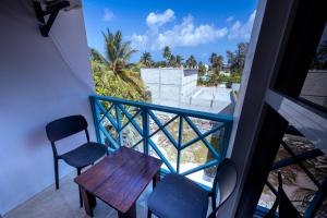 a balcony with a table and chairs and a view at Buceo Inn Mathiveri in Mathiveri