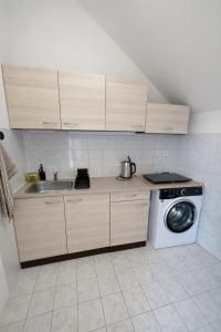 a kitchen with a sink and a washing machine at Apartmán 19 in Mikulov