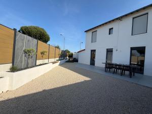 a courtyard of a white building with a picnic table at Cocon d'Aurore in La Baule