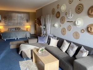 a living room with a couch and a bed at Seehof Hotel am Aartalsee in Bischoffen