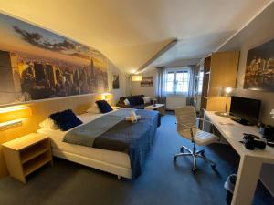 a bedroom with a bed and a desk with a computer at Seehof Hotel am Aartalsee in Bischoffen +19 photos