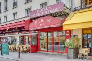 a restaurant on a street with tables and chairs at Hotel Royal Mansart in Paris