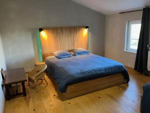 a bedroom with a large bed with a wooden headboard at Au point du jour Ch2 in Récourt-le-Creux