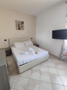 a bedroom with a white bed with towels on it at Casa Mare Relax e Cortesia in Ardea