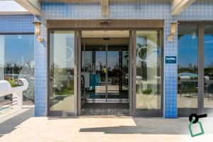 an entrance to a building with glass doors at Hotiday Chioggia Lungomare in Sottomarina