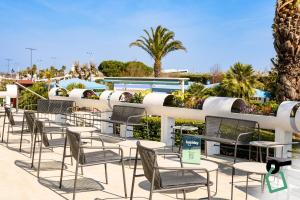 a row of chairs and tables on a patio at Hotiday Chioggia Lungomare in Sottomarina