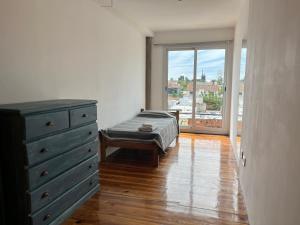 a bedroom with a bed and a dresser and a window at DEPARTAMENTO dos dormitorios en Martinez, cercano a CABA, zona clinicas y oficinas, con AA y Wifi, ideal familias in Martínez +13 photos