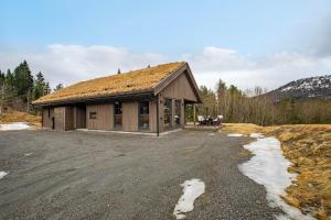a small building with a grass roof on a field at Stryn Mountain Lodge in Stryn