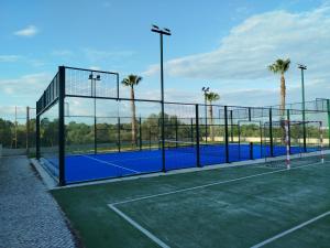 a tennis court with palm trees in the background at VilaBplaza by JohnVillas in Alvor