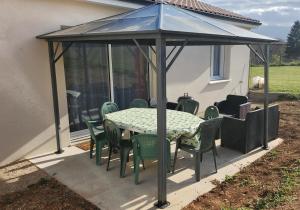 a gazebo with a table and chairs on a patio at Parenthèse 8 pers-6 mns Futuroscope-Famille in Chasseneuil-du-Poitou