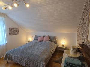 a bedroom with a bed with pink pillows on it at Fewo Lieblingsblick, gemütlich & chic in Bad Münstereifel
