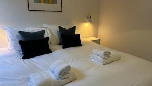 a white bed with two folded towels on it at Findochty - 2 Bed Luxury Apartment by Together Travel in Wick