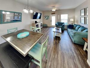 a living room with a table and a green couch at Trestles in Padre Island