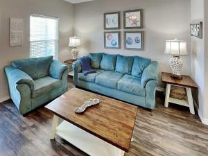 a living room with a blue couch and a coffee table at Trestles in Padre Island