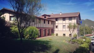 una casa grande con un patio de hierba delante de ella en Hotel Ibaigune, en Murueta
