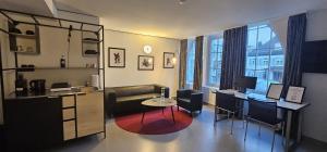 a living room with a table and a desk with a computer at RS Boardinghouse Aparthotel mit Charme und Hotelservice in St. Gallen