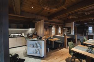 a kitchen and dining room with tables and chairs at Hotel Weiler - Aktiv & Tradition in Obertilliach