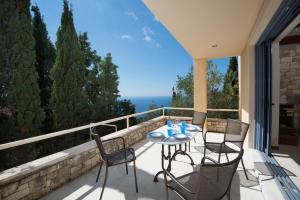 a patio with a table and chairs on a balcony at Villa Pelagos in Arvanitakaíïka