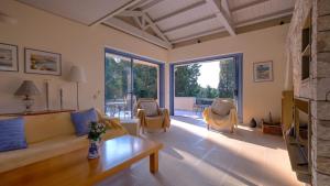a living room with a couch and a table and chairs at Villa Pelagos in Arvanitakaíïka