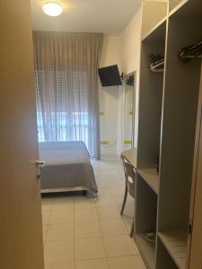a bedroom with a bed and a desk in a room at Hotel Aron Rimini in Rimini