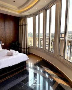a bedroom with a bed and large windows at Kanaan Group Hotel in Baalbeck