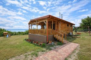 a log cabin with a porch and a deck at Ádám nyaralóház in Balatonalmádi