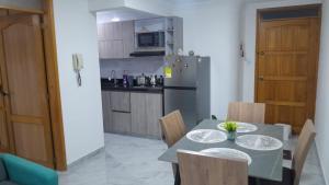 a kitchen with a table with chairs and a refrigerator at El Encanto in Duitama