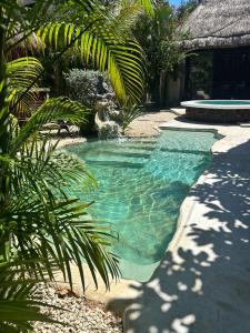 a swimming pool with green water in a resort at Aldea Pukna Tulum in Akumal