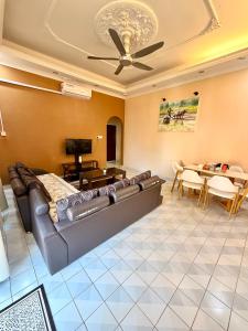 a living room with a couch and a table at NorvillaB Pantai Cenang in Pantai Cenang