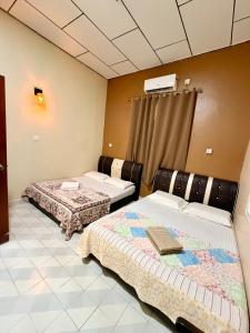 a room with two beds in a room at NorvillaB Pantai Cenang in Pantai Cenang