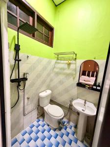 a bathroom with a toilet and a sink at NorvillaB Pantai Cenang in Pantai Cenang