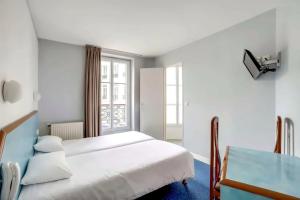 a bedroom with a white bed and a window at Hotel Royal Mansart in Paris
