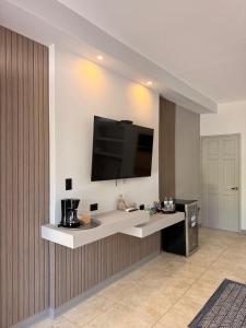 a kitchen with a counter with a tv on the wall at Guayacan Real Deluxe in Nicoya
