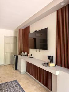a room with a counter with a tv on a wall at Guayacan Real Deluxe in Nicoya