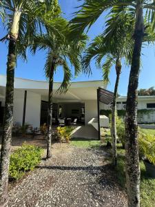 a house with palm trees in front of it at Guayacan Real Deluxe in Nicoya